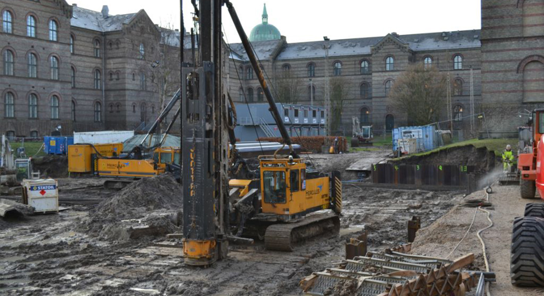 Byggegrund med gamle bygninger i baggrunden