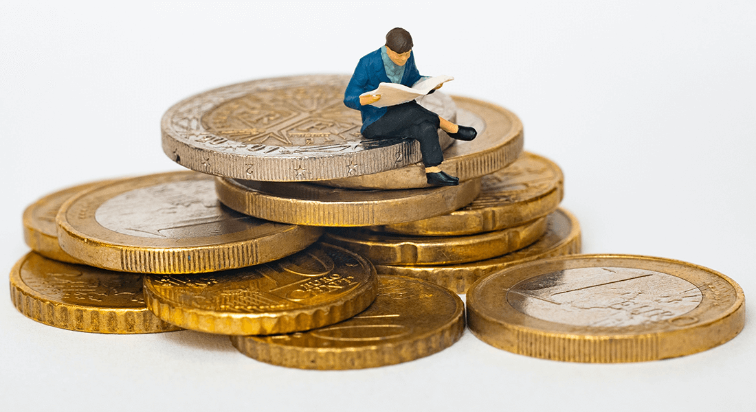 Figurine on pile of money. Photo: Mathieu Stern, Unsplash